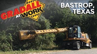 Wheeled excavator with flail mower clearing overgrown roadside vegetation [upl. by Annavoig]